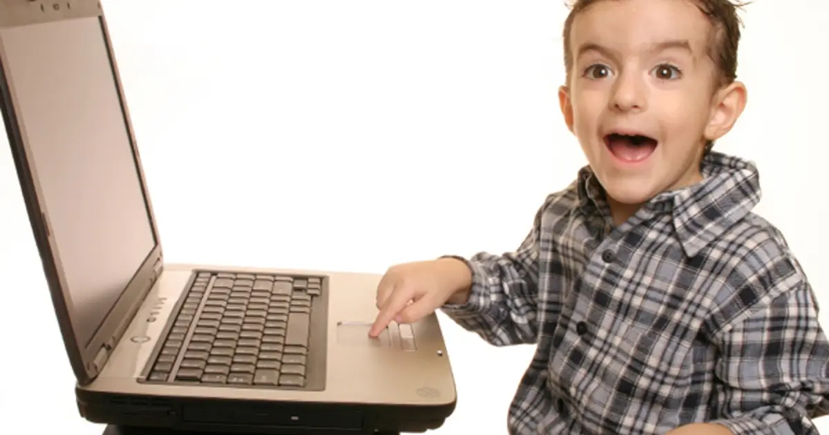 Young boy on laptop - smiling and happy