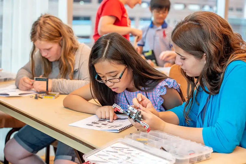 Children at a desk with electronics attending the annual SPARK! event at Mensa's Annual Gathering.